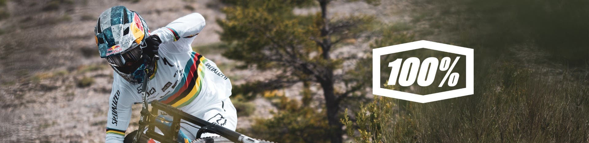 Man wearing 100% goggles on face hitting a jump on dirt bike