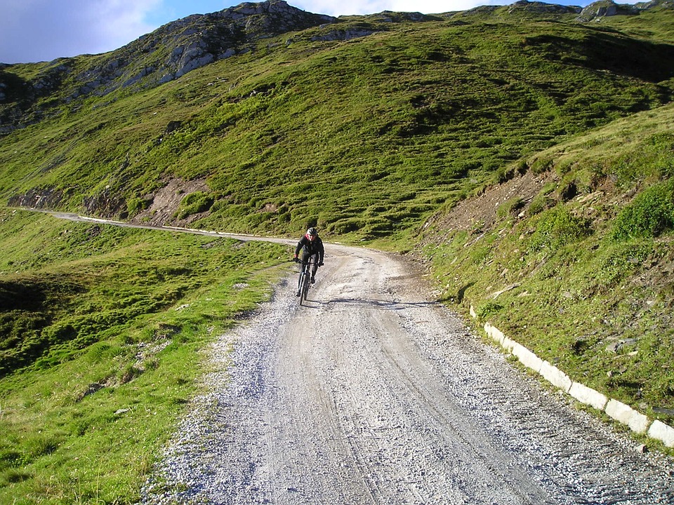 man biking down gravel road