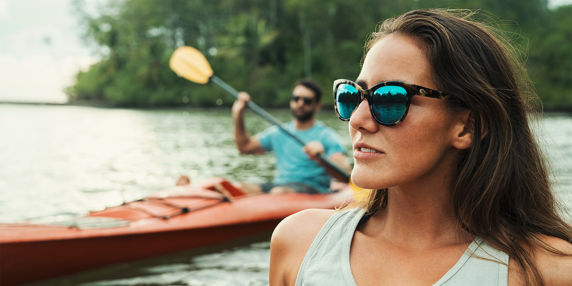 woman wearing costa blue light sunglasses while kayaking