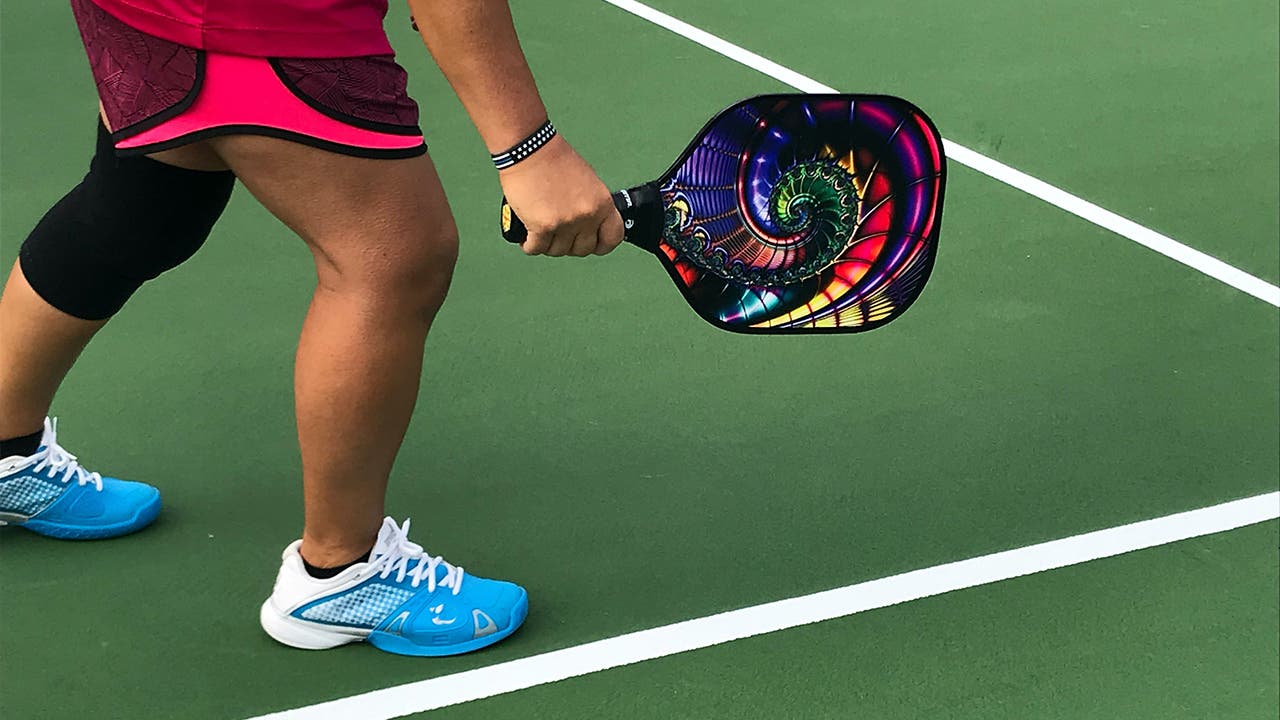 woman on a pickleball court holding a pickleball racket